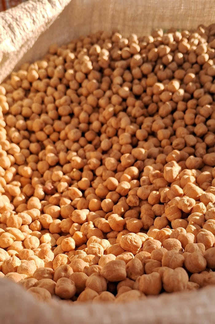 about-img A rustic display of uncooked chickpeas in a burlap sack, showcasing natural texture.