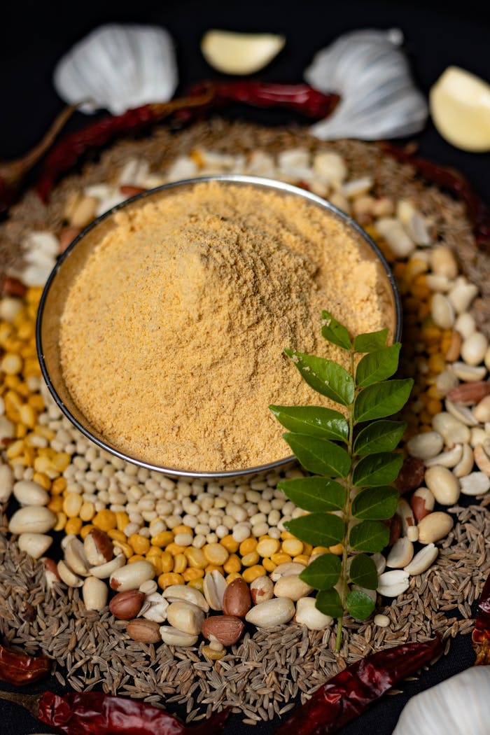 hero-img-01 Traditional Indian spice blend surrounded by mixed lentils, nuts, and herbs in Dindigul, Tamil Nadu.